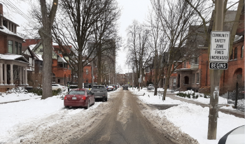 Residential street after snow clearing has some snow on the road surface. 