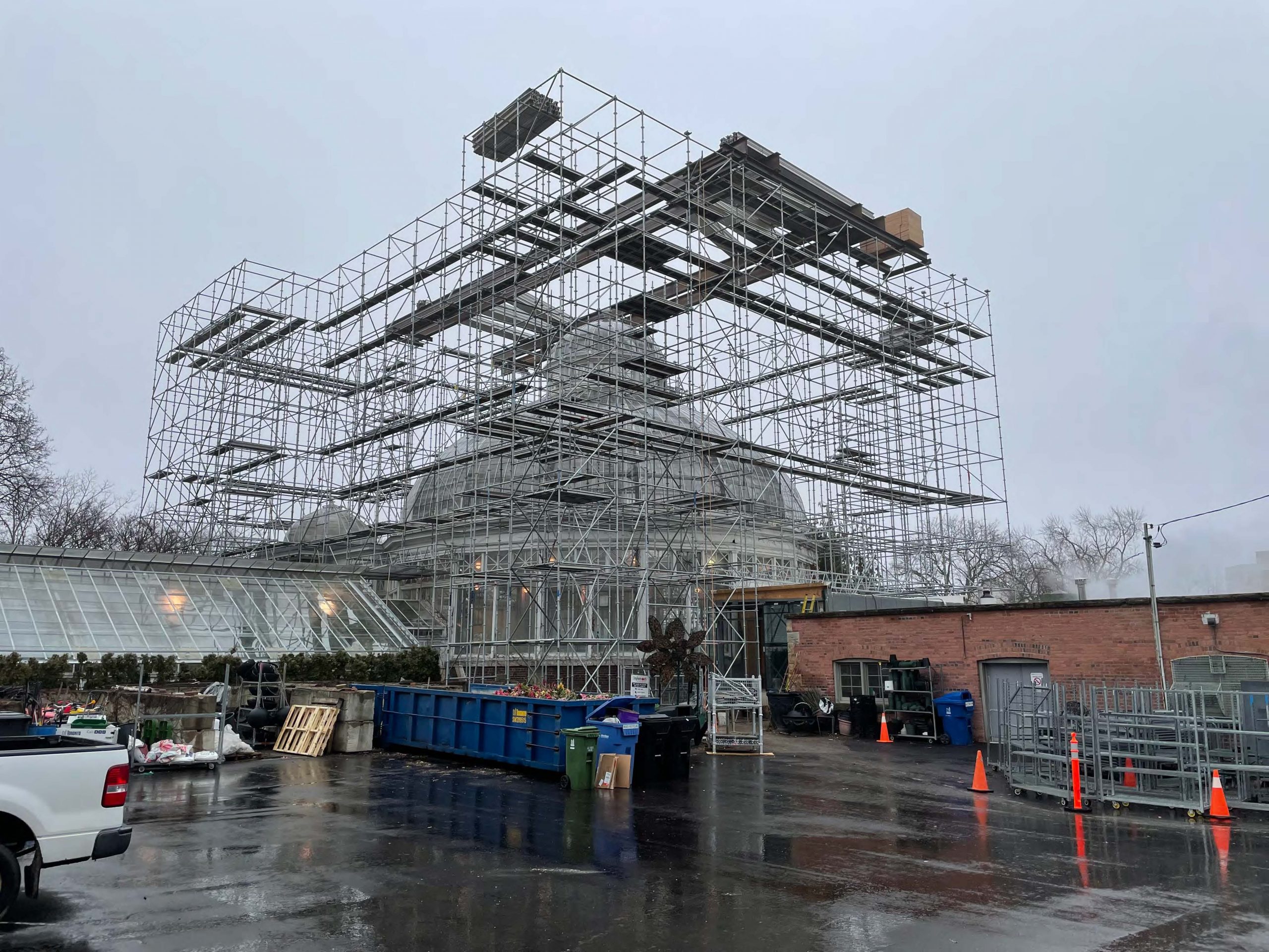 A photograph of the steel scaffolding structure at Allan Gardens Palm House which shows a tall framework structure with platforms and steel beams. 