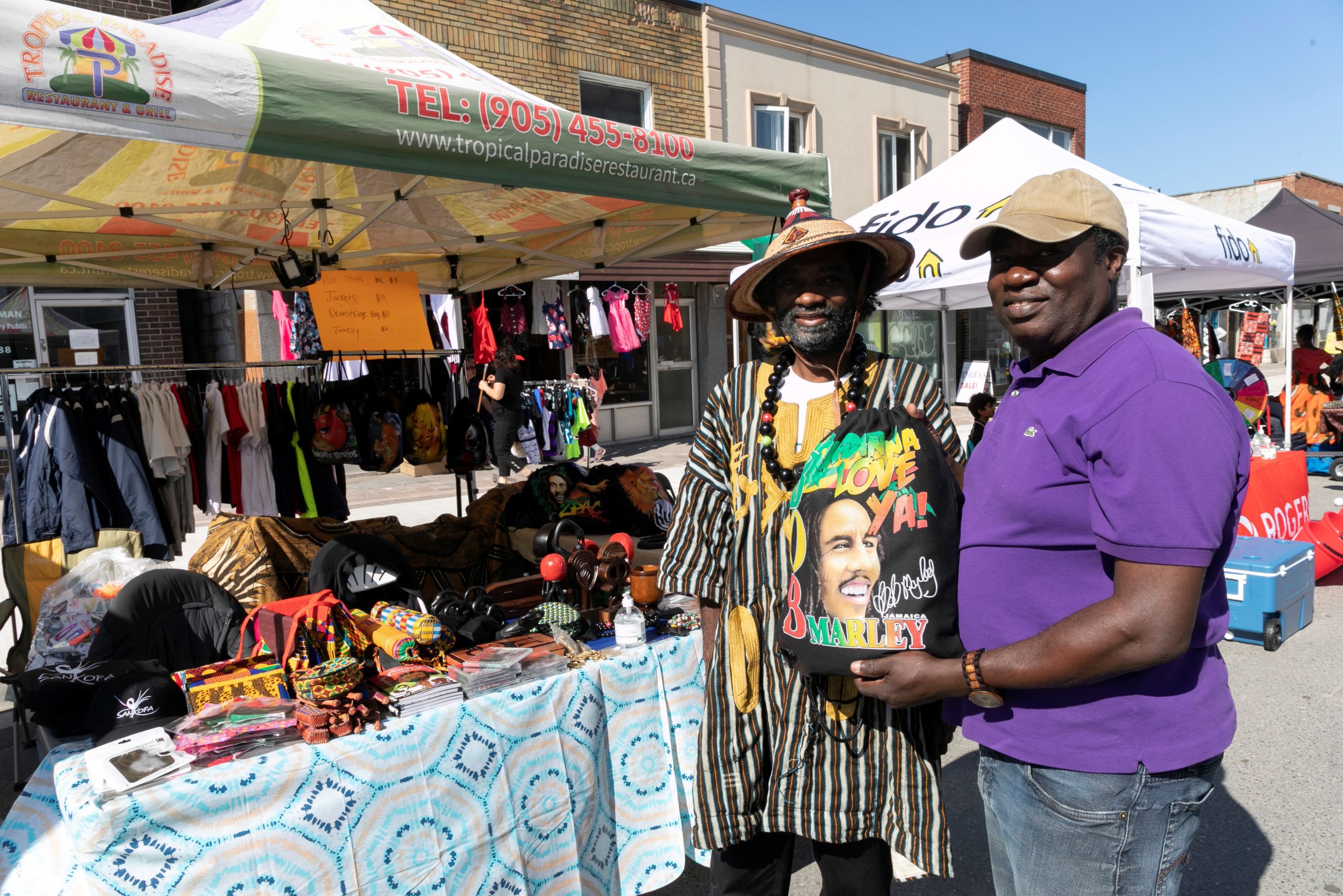 Two men standing in front of a roadside stall