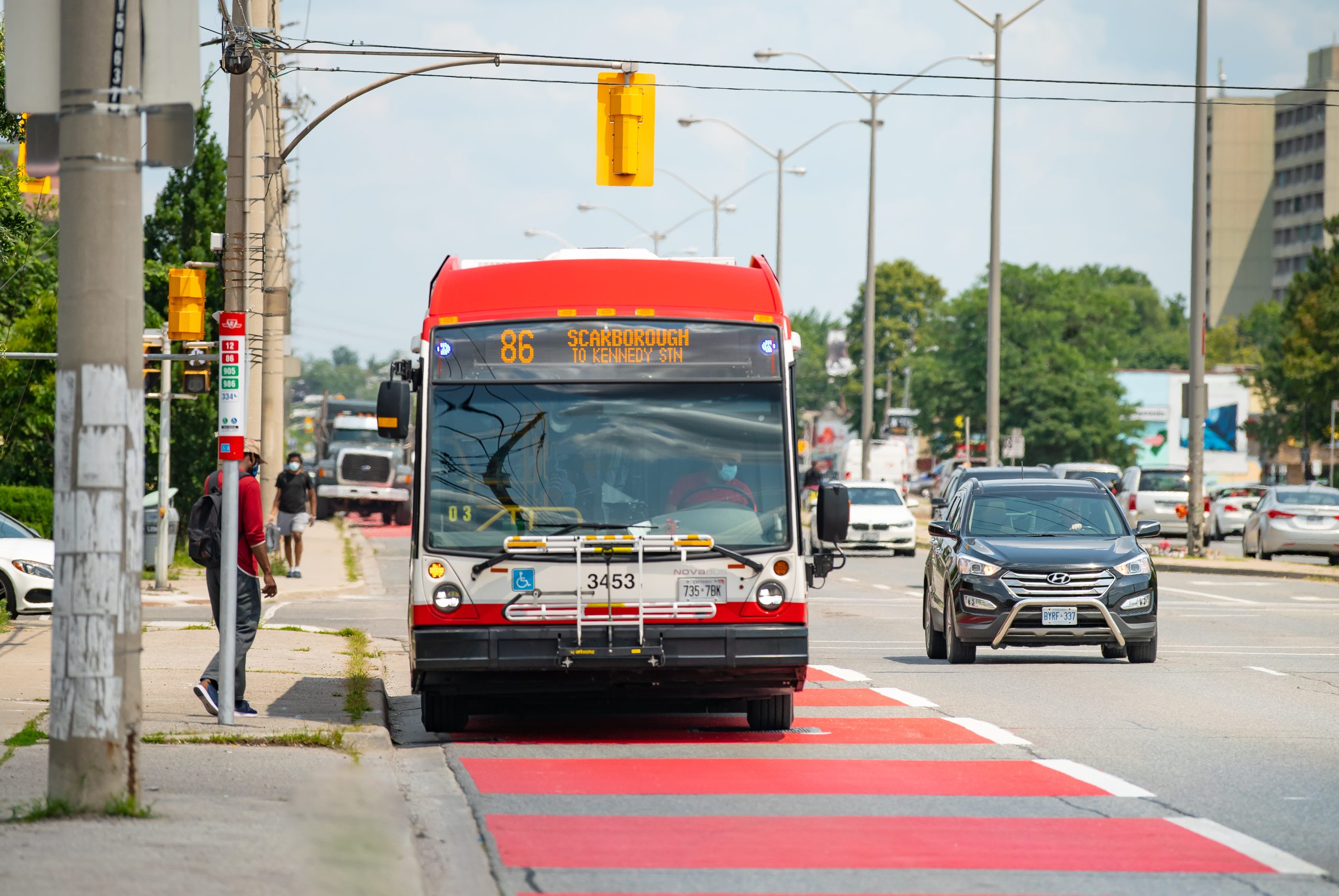 The 86 Scarborough bus arriving at a bus stop on a priority roadway..