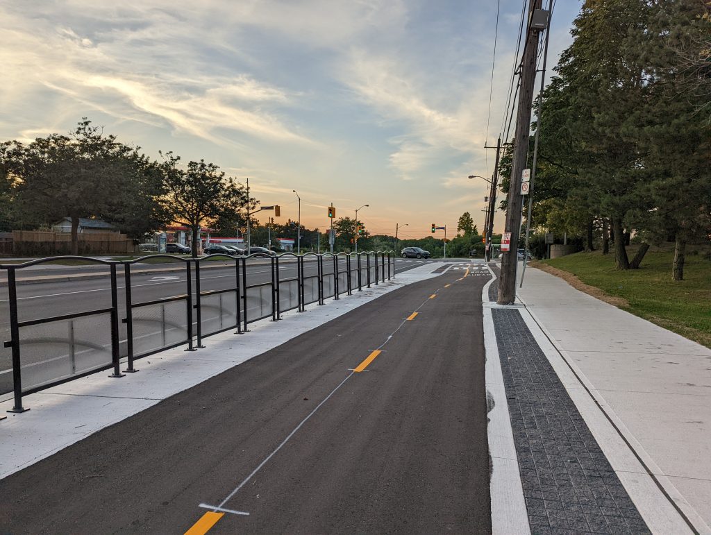 A multi-use trail is shown in the boulevard of Kipling Avenue, with a sidewalk on one side and protective barriers on the other.