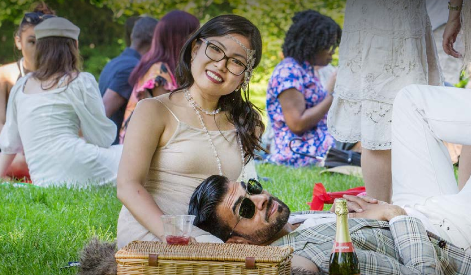 Two people facing the camera in vintage costumes at a picnic