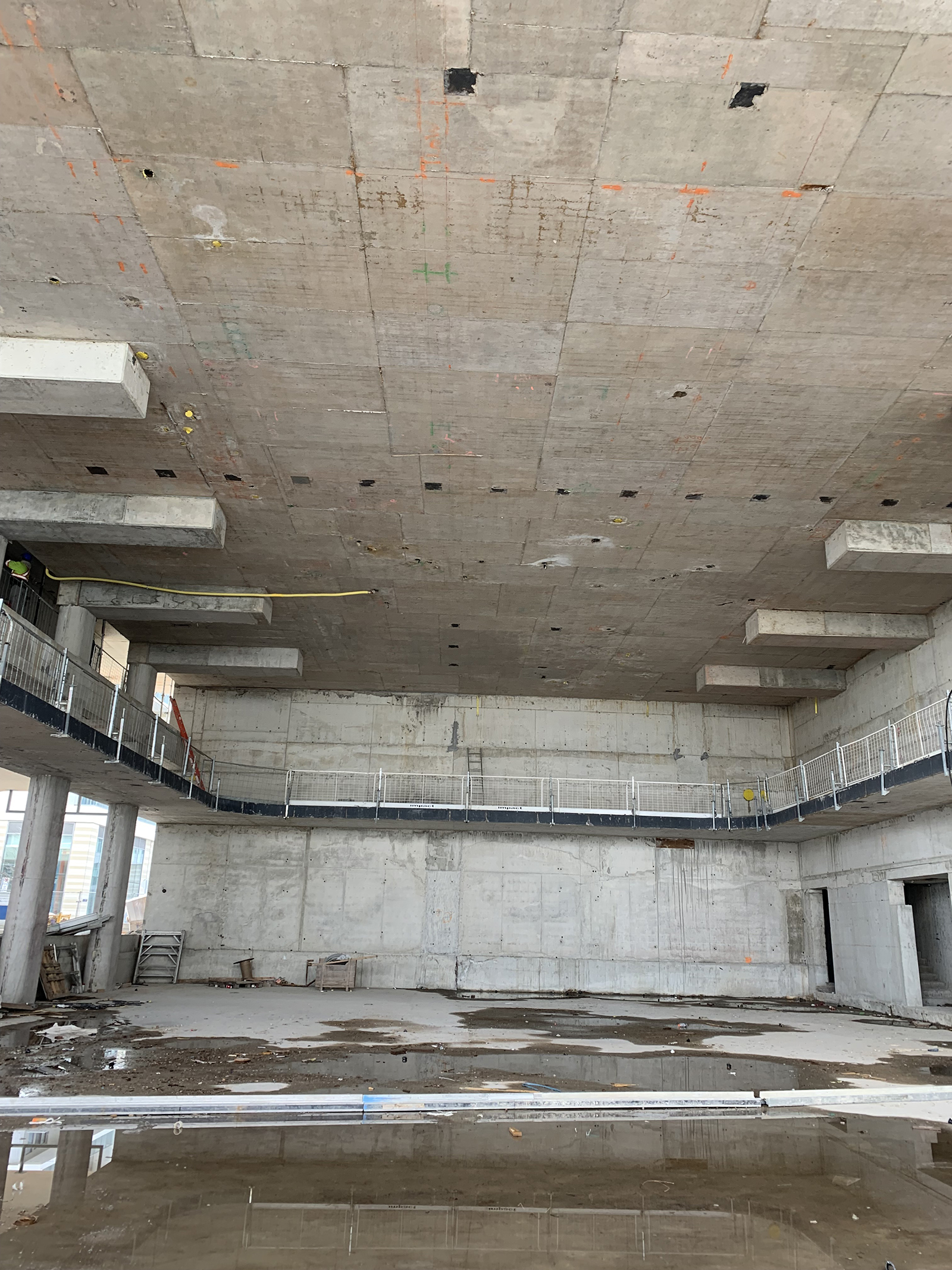 Photograph of the construction for the new East Bayfront Community Recreation Centre, showing the indoor double gymnasium under construction with concrete.