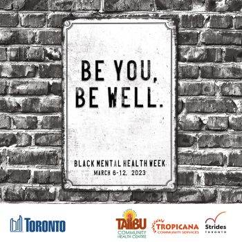 Black and white image of a sign posted against a partial brick wall that reads Be You, Be Well Black Mental Health Week March 6-12, 2023