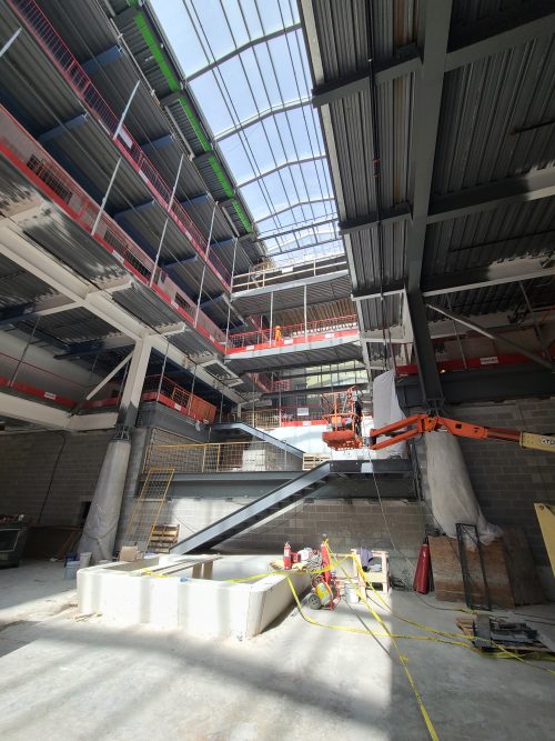 Interior view of St. Lawrence Market, North Building atrium showing yellow construction tape, a crane and the two upper levels.