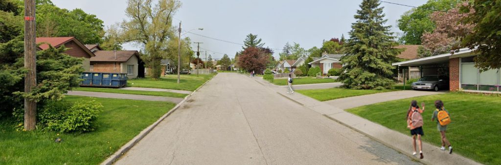 A rendering shows an an image of a residential street, with children walking on a sidewalk on one side of the street.