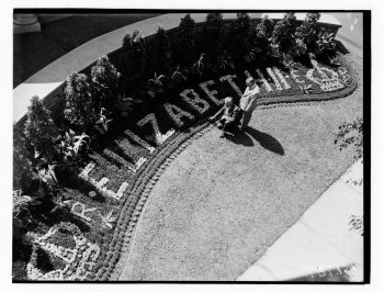 Black and white photograph depicts flower arrangement spelling Elizabeth II