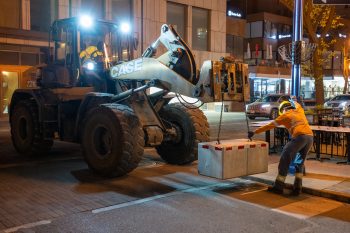 Crew member pulls concrete block into position