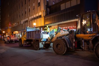 Construction equipment moves traffic safety blocks into place.