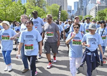 Group of people smiling and walking downtown in matching Toronto Challenge t-shirts