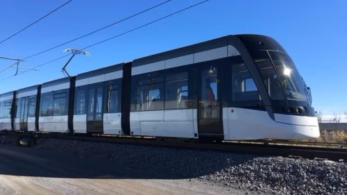 Example photo of a light rail transit vehicle from the Eglinton Crosstown Light Rail Transit. The 5-segment vehicle is powered by overhead cables and runs along a set of tracks.