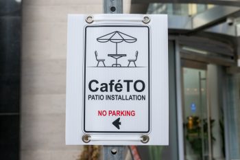 CafeTO no parking sign ahead of traffic safety equipment installation.