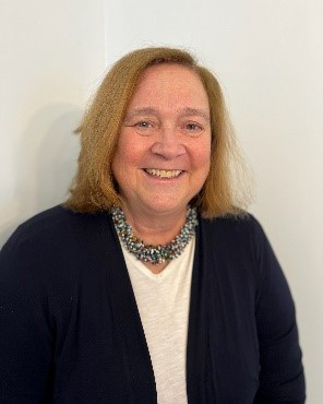 Ann Doggett wearing a blue sweater, smiling.