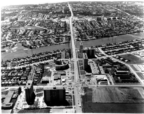 Image depicts oblique aerial view of urban street intersection taken from aircraft