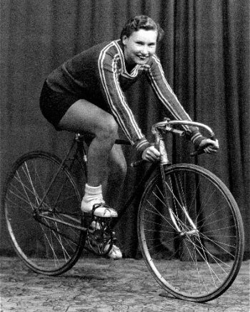 A black and white photo of Nora Young on a bicycle. 
