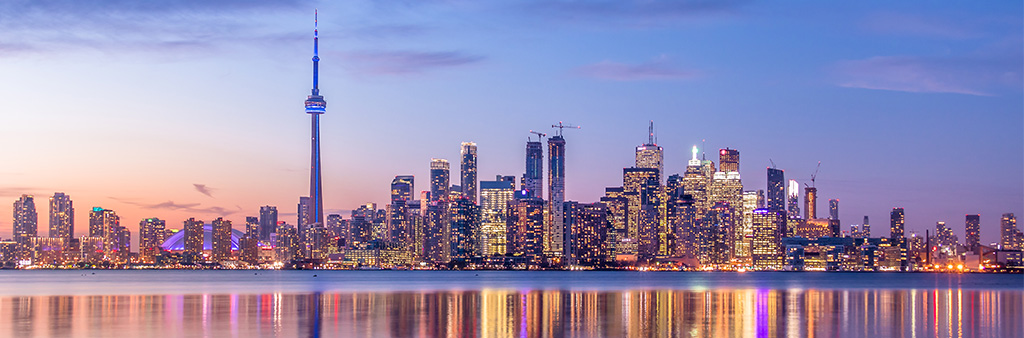 Toronto skyline at dusk looking over the lake to downtown waterfront buildings