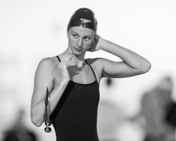A black and white photo of Summer McIntosh, in a bathing suit and cap.