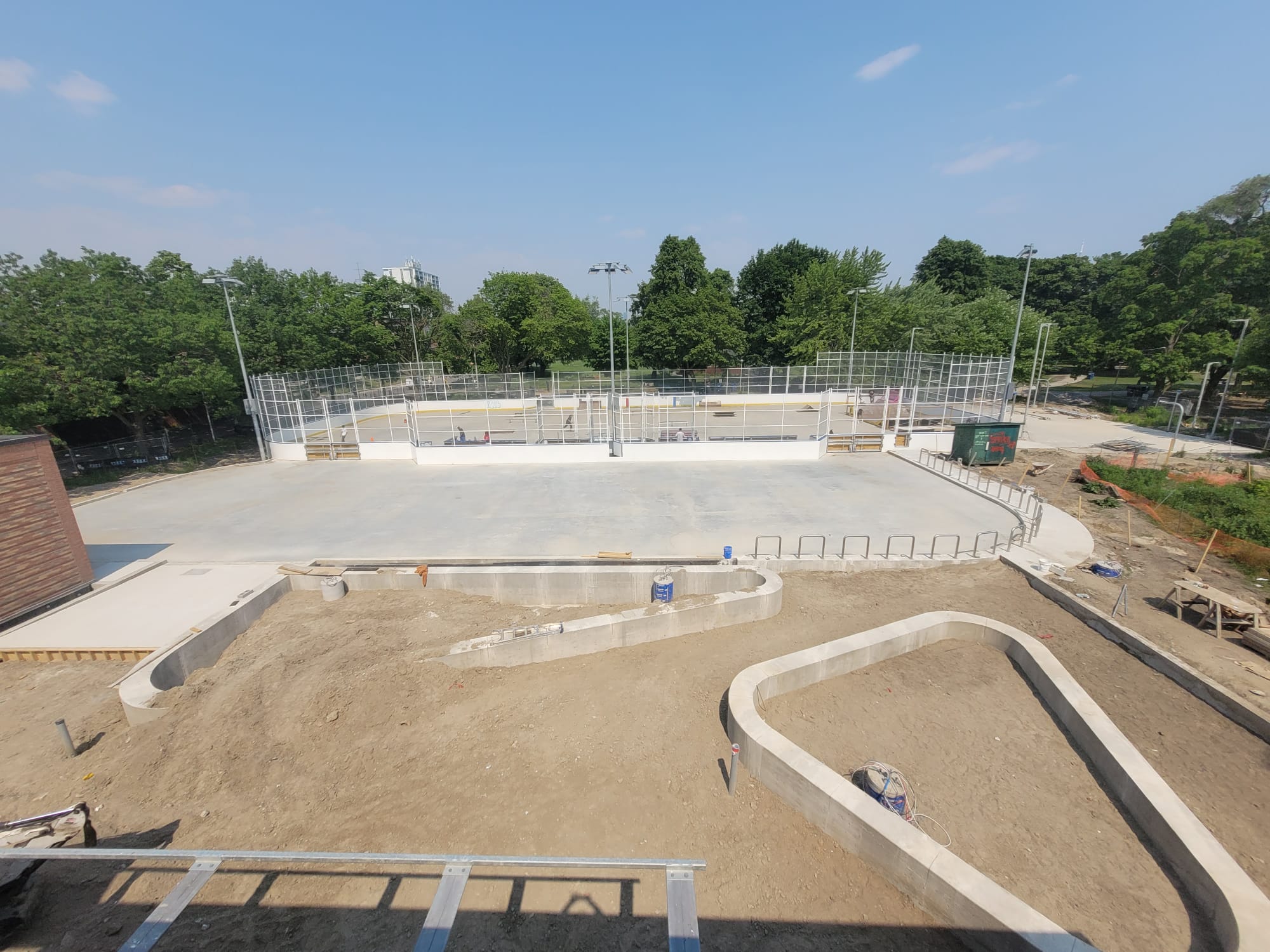 Photo taken from roof of Clubhouse looking down into area where new public plaza will be. The foundations for two large triangular planters have been excavated. The concrete around the planters is completed. 