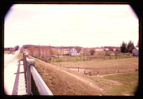 Image depicts photograph of farmland and farm buildings