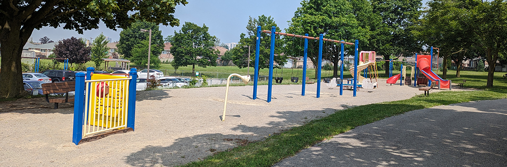 Grandravine Park Playground which shows play panels, a talk tube, a swing set and two standalone play structures on top of sand. The play equipment is show in blue, yellow and red.