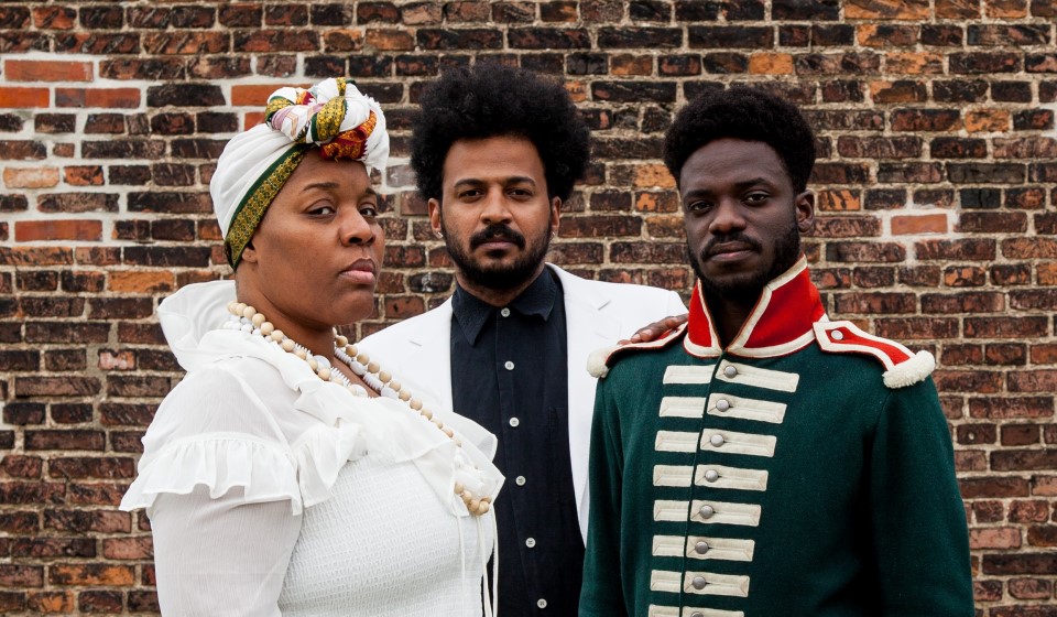 Three people against a brick wall.