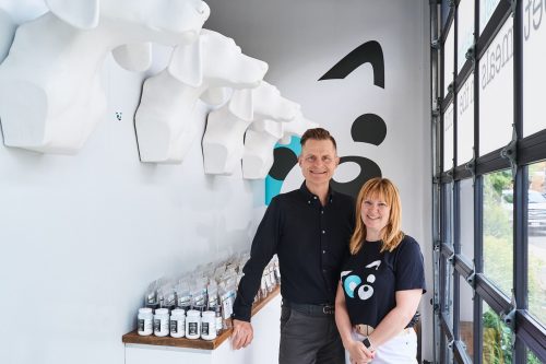 Two people stand beside merchandise display inside store