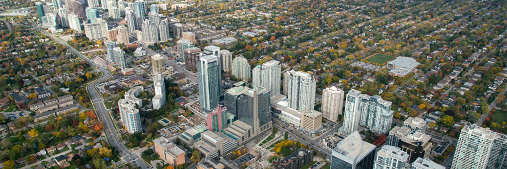A bird's eye view photo of North York Centre looking northeast. The photo shows a linear concentration of taller buildings surrounded by primarily low-rise residential neighbourhoods.