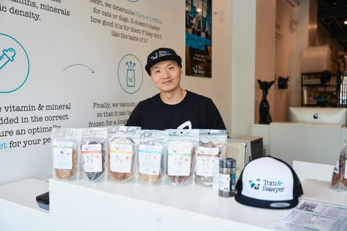 Person stands behind merchandise display at store checkout counter