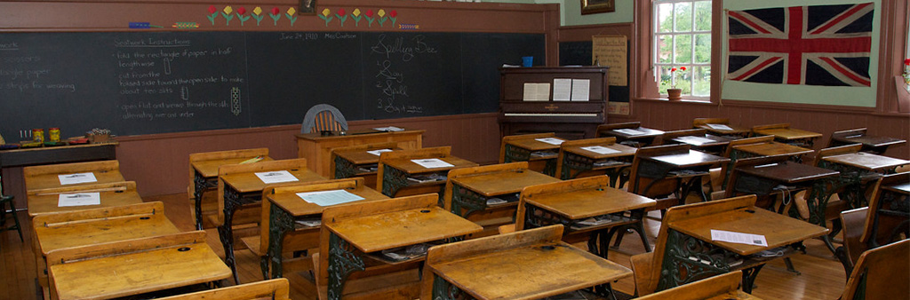 A classroom with antique desks and artifacts from the early 1900s