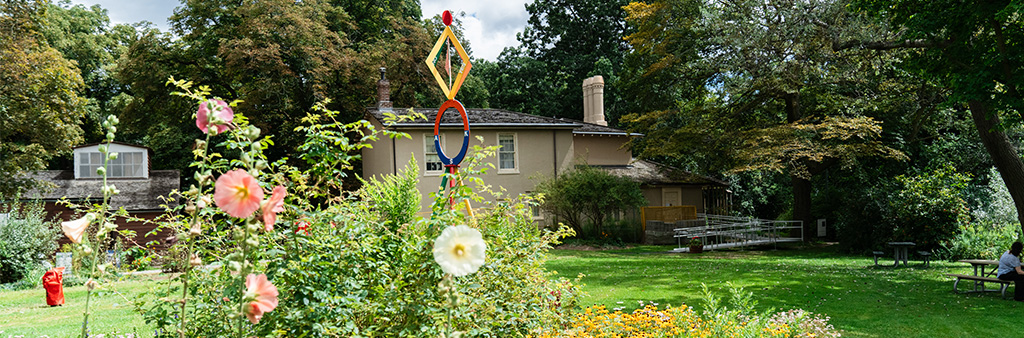 Exterior of Colborne Lodge in High Park with garden and picnic benches