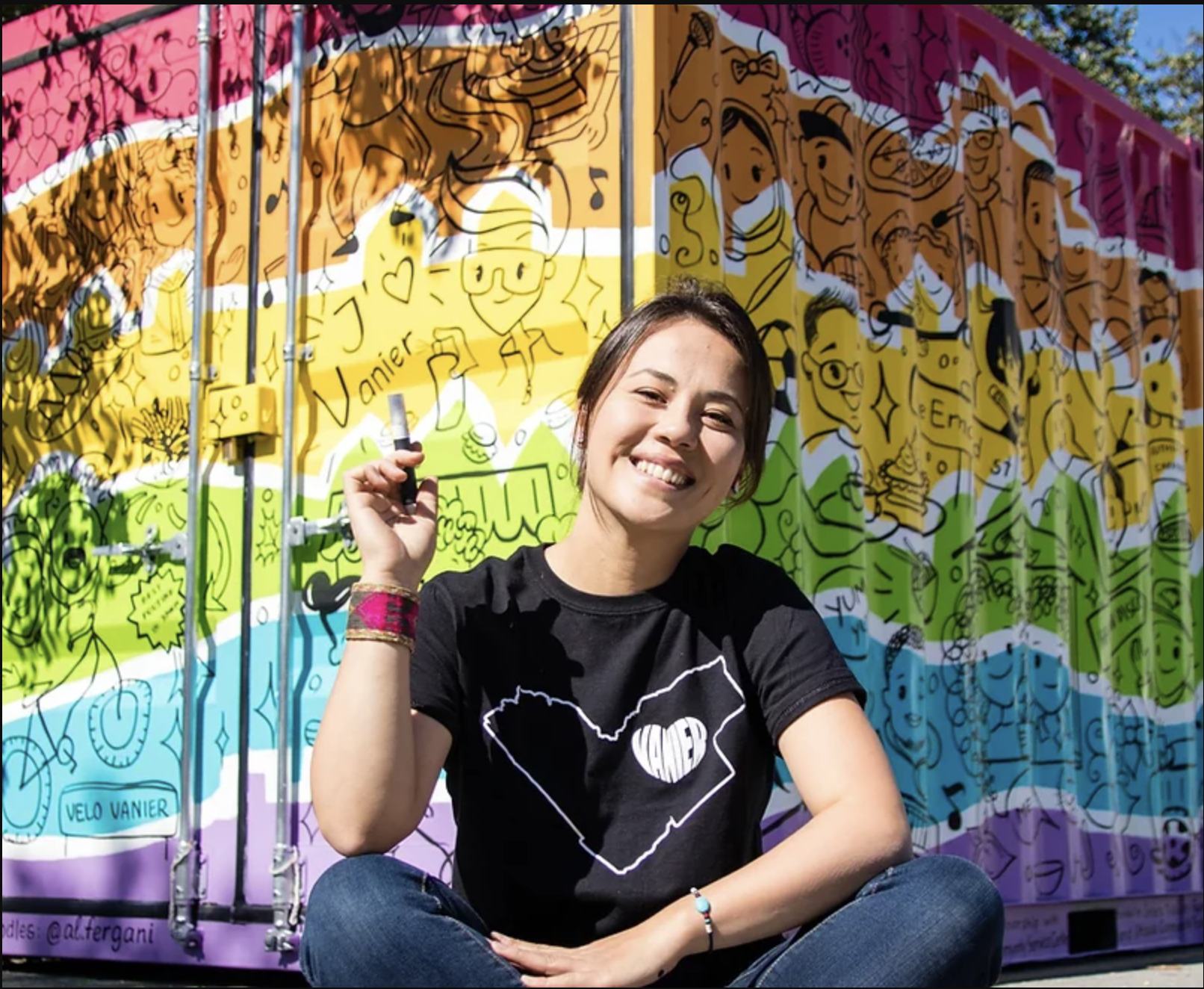 Artist Kseniya Tsoy poses in front of a mural