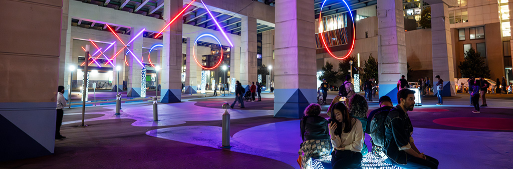 Large Neon "Xs and Os" lit up in the night under an expressway