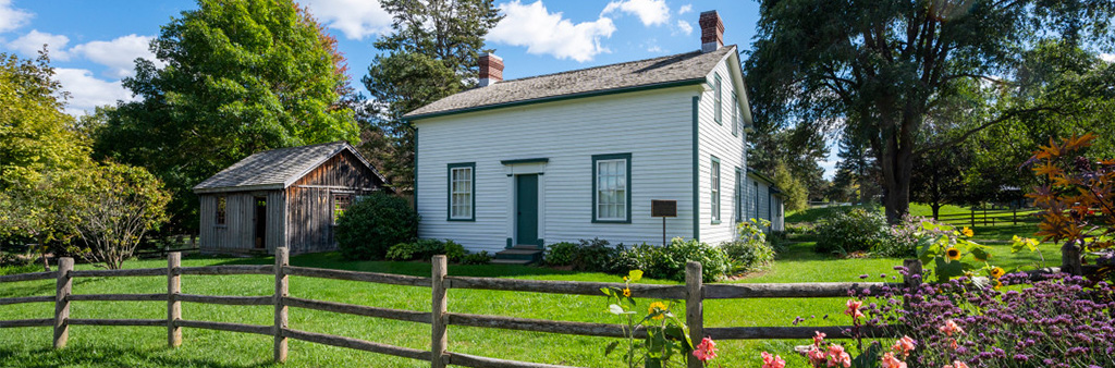 The exterior and surrounding grounds of Scarbourough Museum on a sunny day