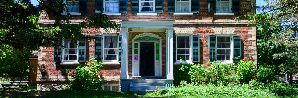 Red brick facade of the Gibson House Museum building, focused on the first storey and half of the second storey.