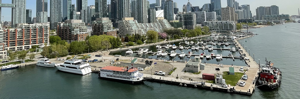 An aerial of Spadina Pier facing north showing the marina in the foreground and condominiums in the background.