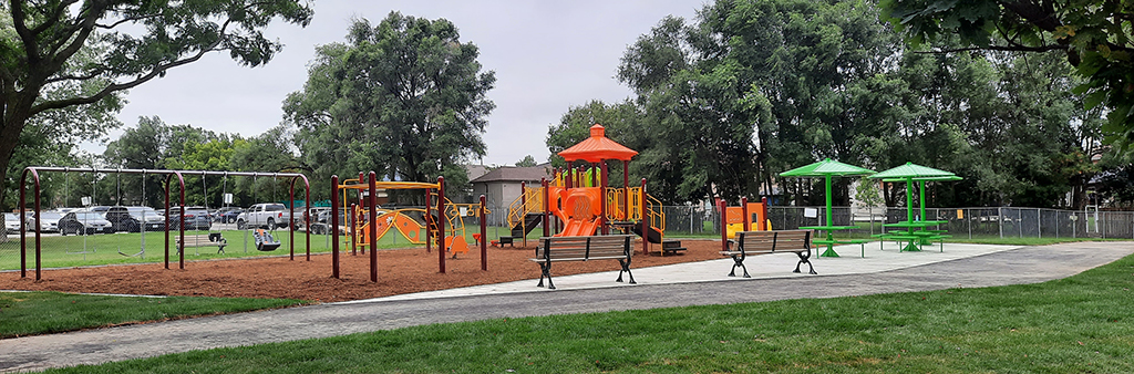 A photograph of the new playground in St. Lucie Park, with climbing structures and swings.