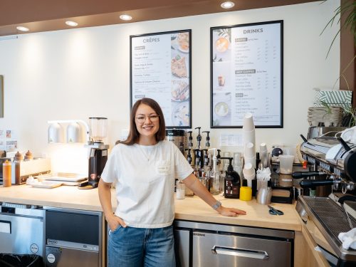 Person leans on counter of café kitchen