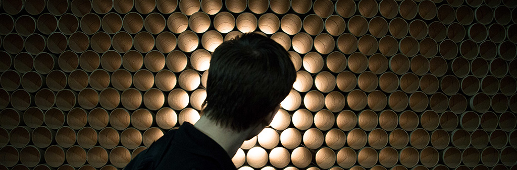 Back of person's head in front of wall of tubes