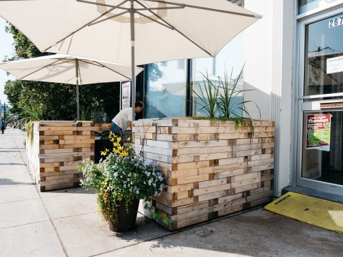 Sava storefront with patio and umbrellas on sidewalk