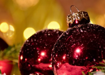 Red holiday decorations with lights in background.