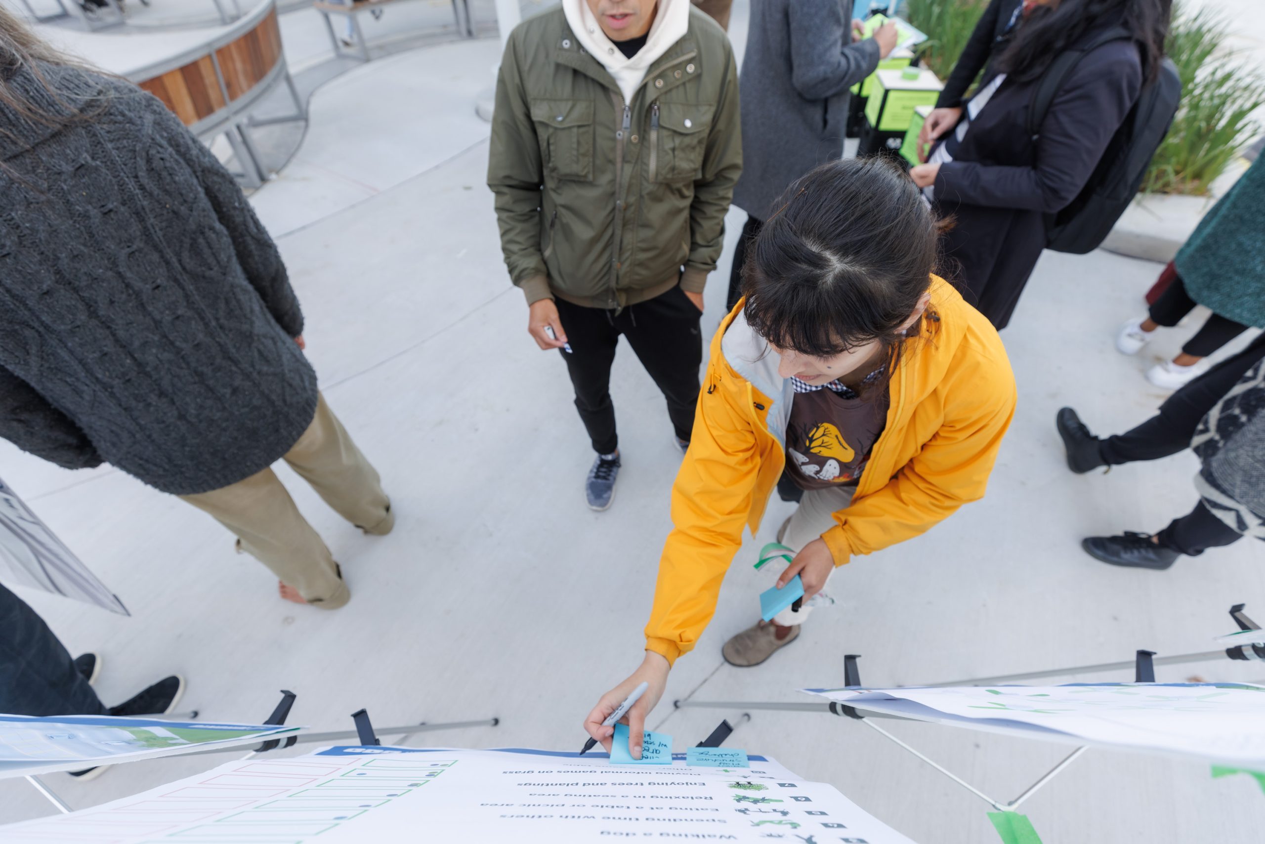 Parks, Forestry and Recreation staff posting a sticky note on an engagement board to have a physical record of the feedback and for other community members to see and interact with the input.