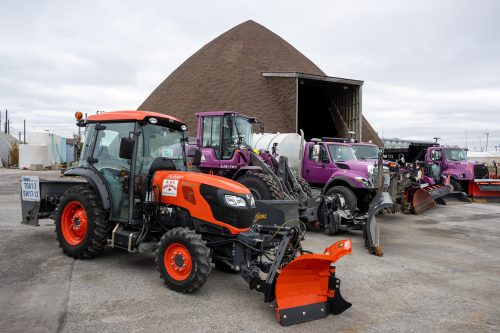 various city snow removal machines parked at a holding yard