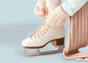 Person tying up laces on a figure skate.