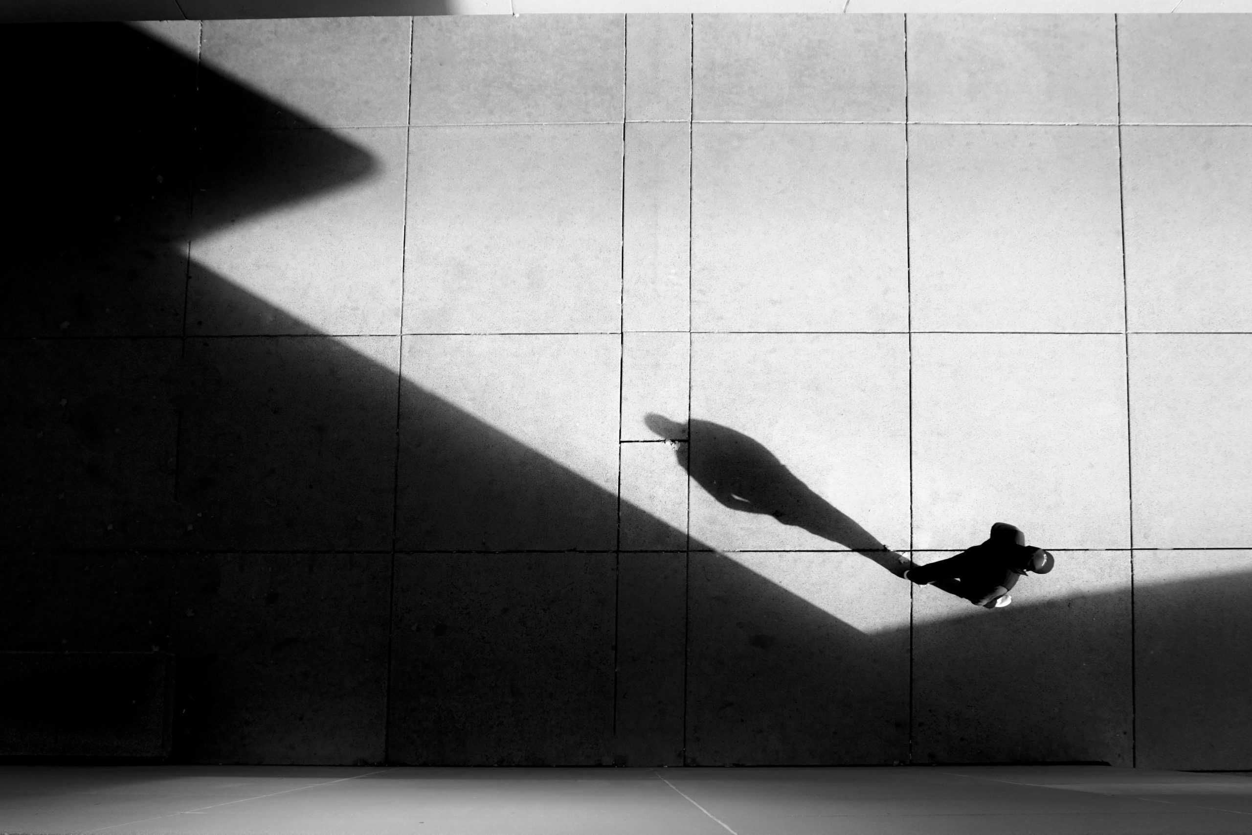 Silhouette aerial photography shot of a person standing next to a shadow of a building