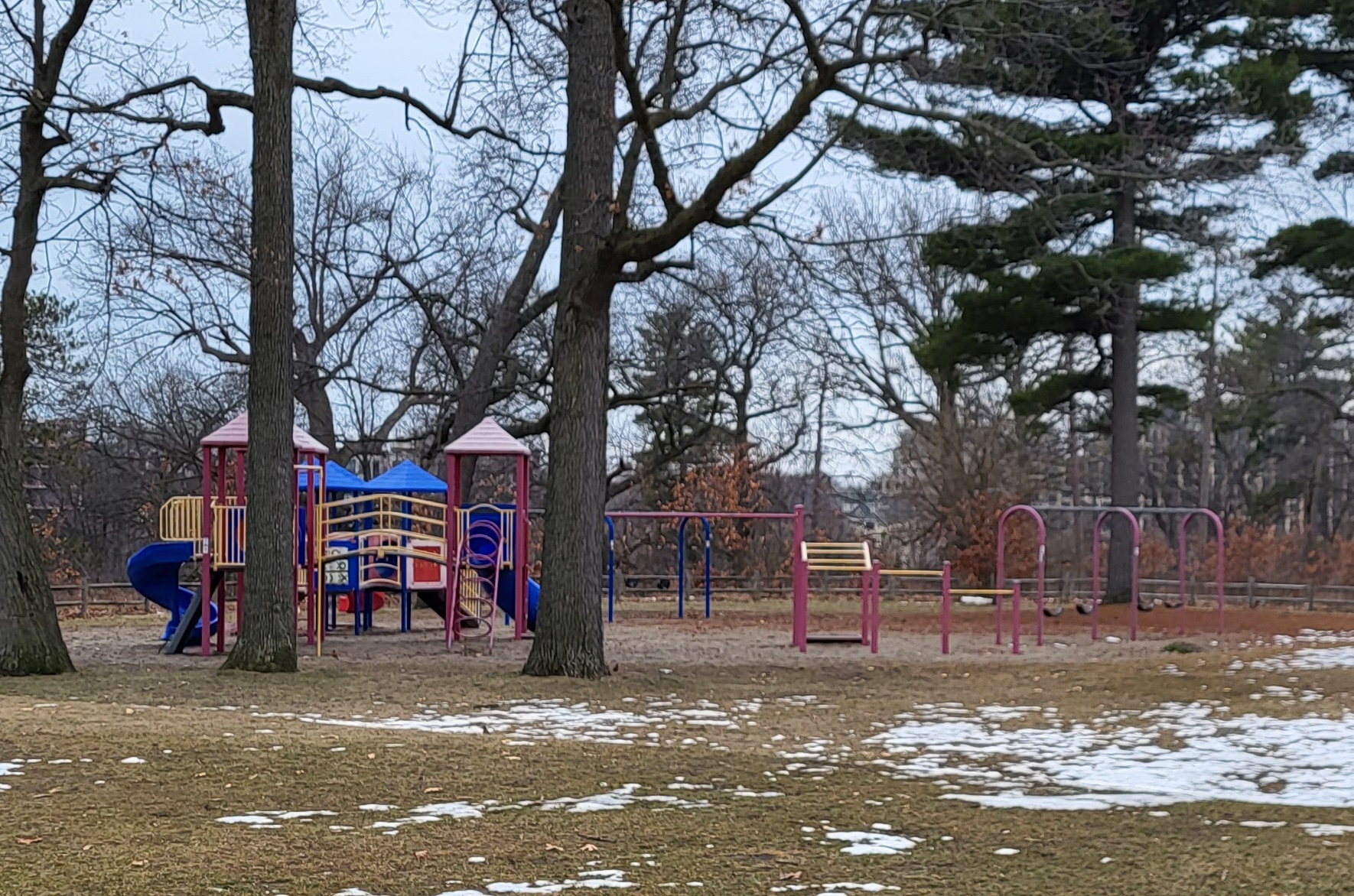 Photo of Lambton Park playground before construction, featuring two swing sets and a combined junior/senior climbing structure with various slides.