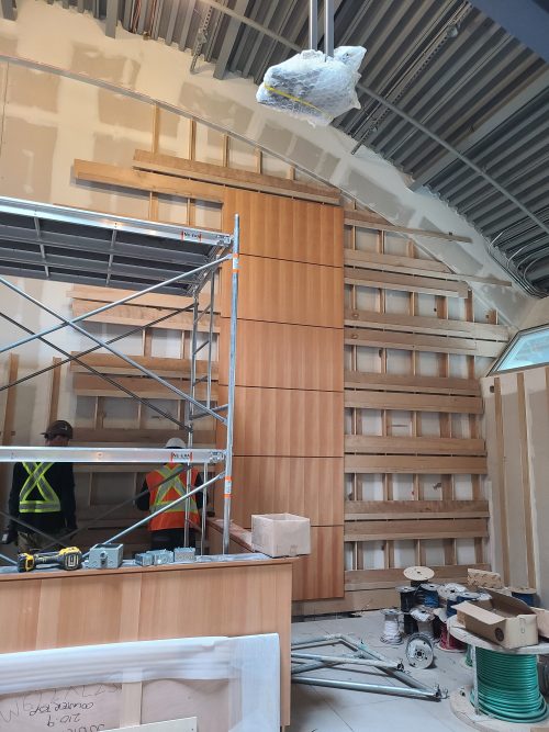 Interior view of Courtroom showing construction workers and construction tools.