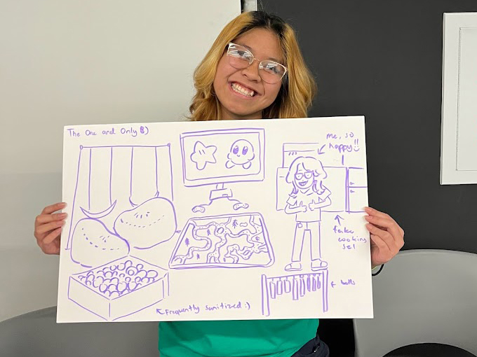 A recreation staff member holds up a sketch of their ideal playground at a workshop.