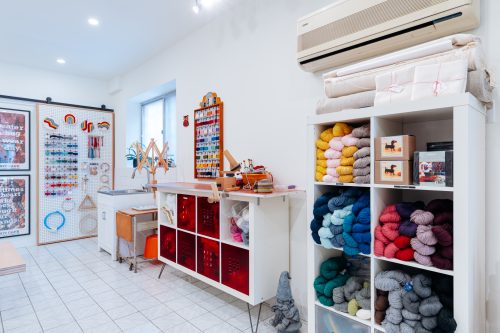Interior view of a knitting shop with colourful wool and other supplies.