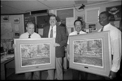 Group portrait of TTC employees receiving framed prints.