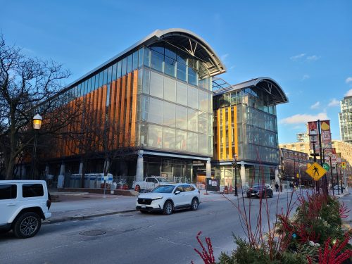 Outside view of St. Lawrence Market, North Building in evening light with cars parked outside.